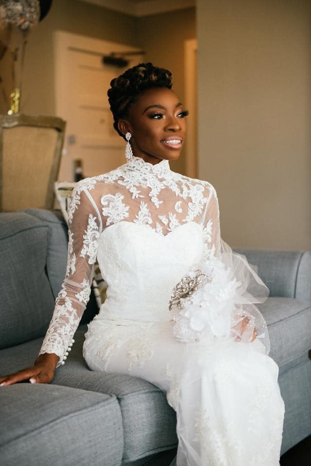 A woman in a wedding dress is sitting on a couch.