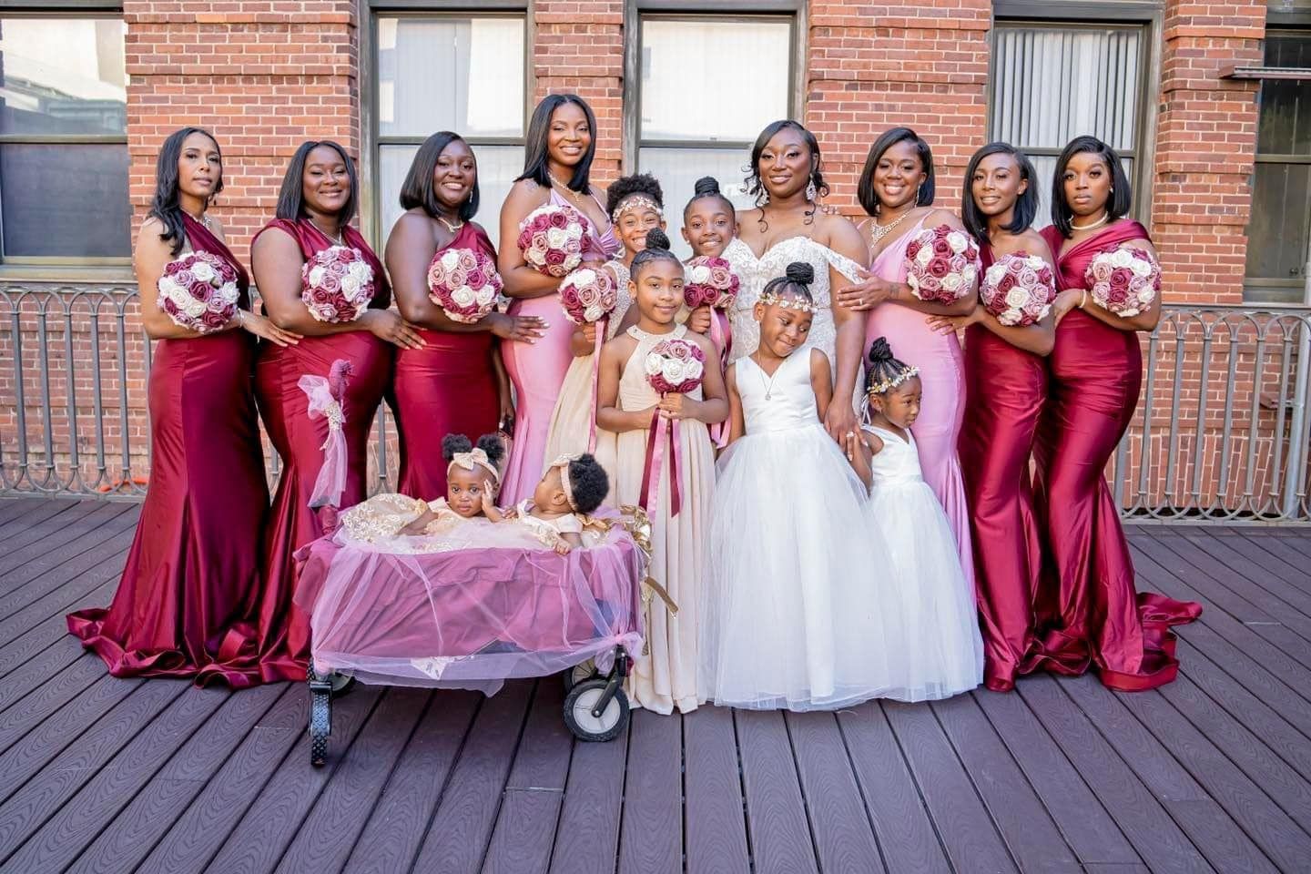 A bride and her bridesmaids are posing for a picture in front of a brick building.