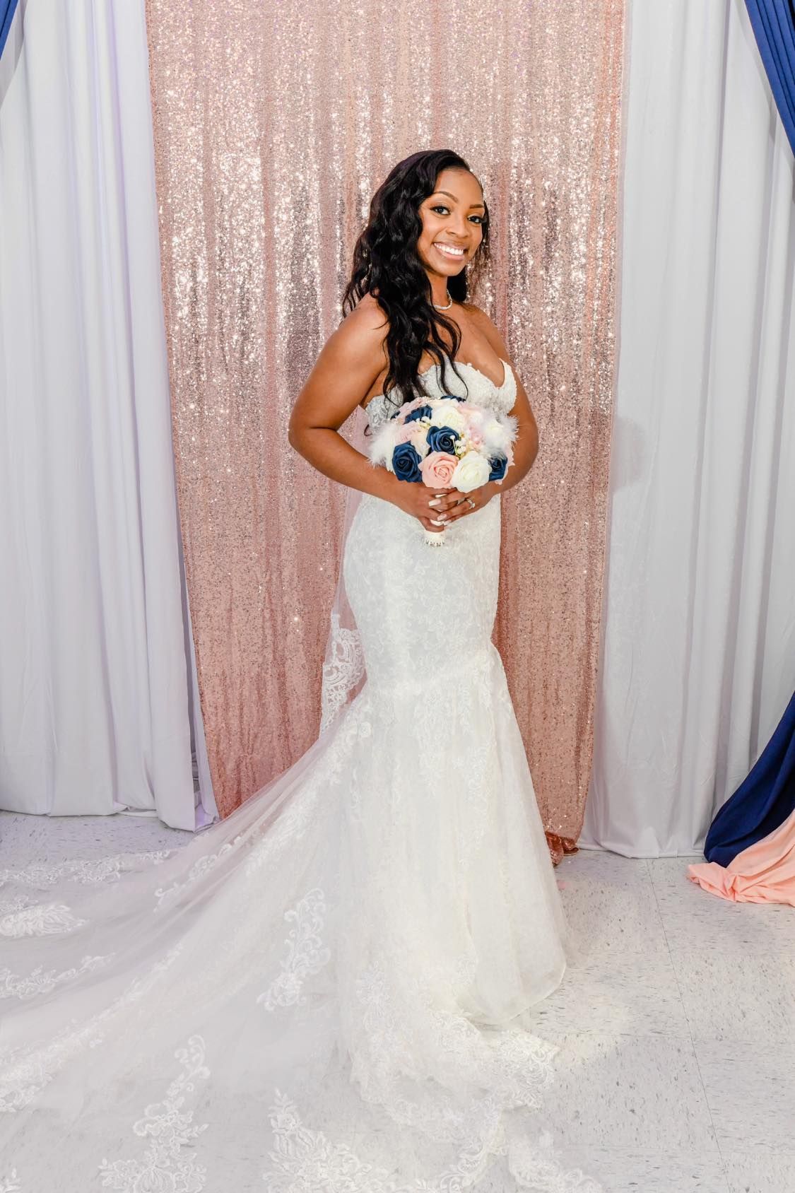 The bride is wearing a wedding dress and holding a bouquet of flowers.