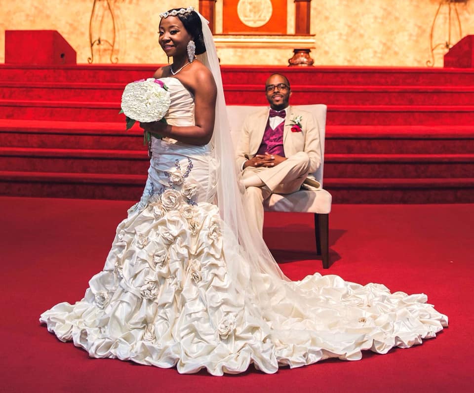 A bride and groom are posing for a picture in a church.