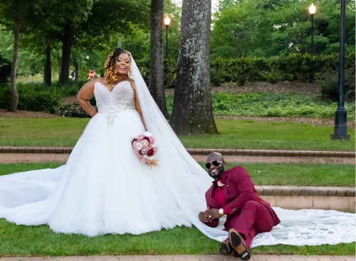 A bride and groom are posing for a picture in a park.