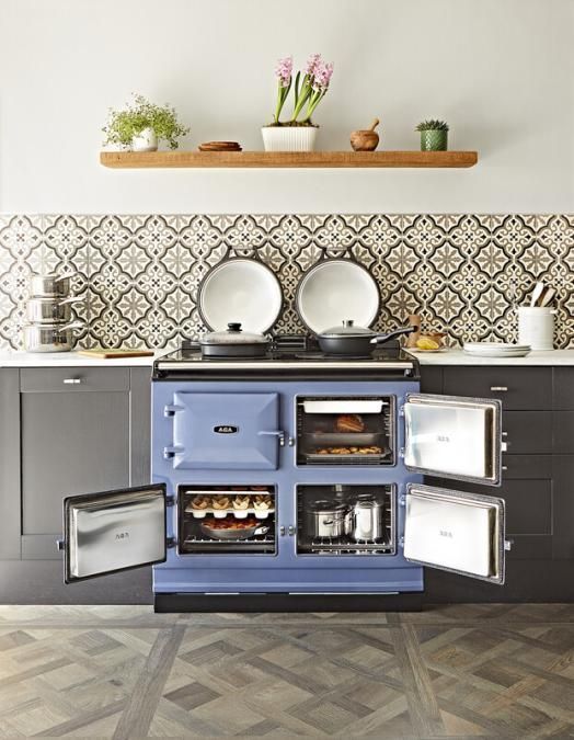 Photograph of Blue AGA eR3-100 Cast Iron Range Cooker, installed in a modern kitchen with oven doors open.