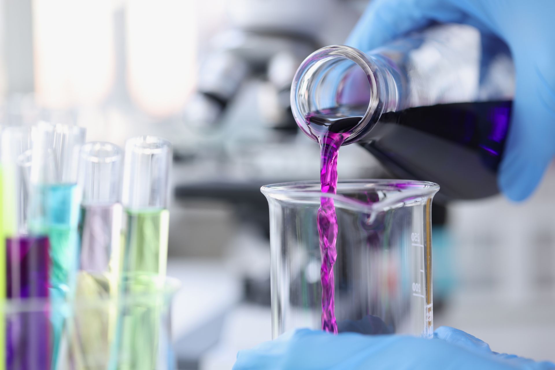 A person is pouring purple liquid into a beaker.