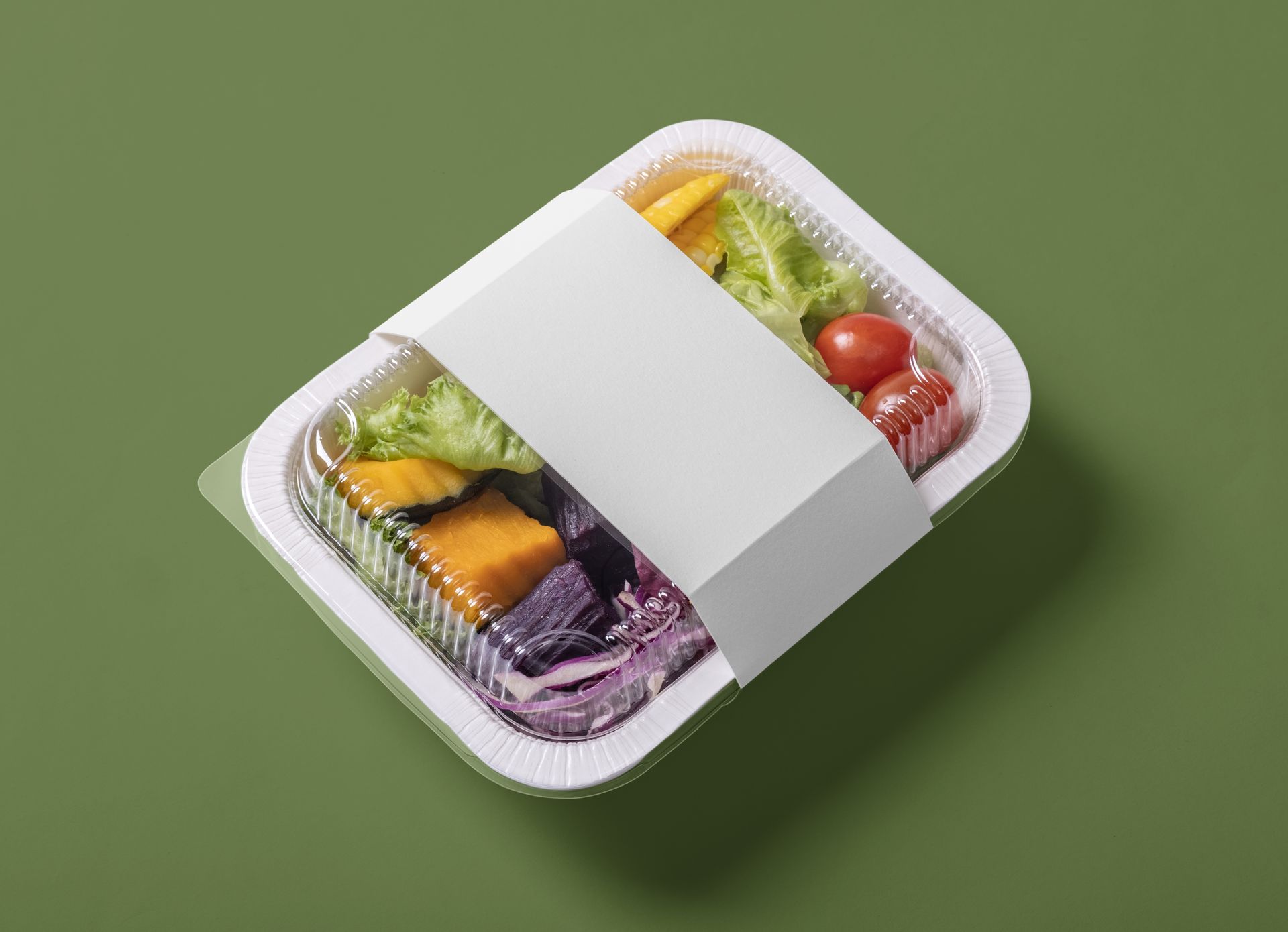 A plastic container filled with vegetables and a white label.