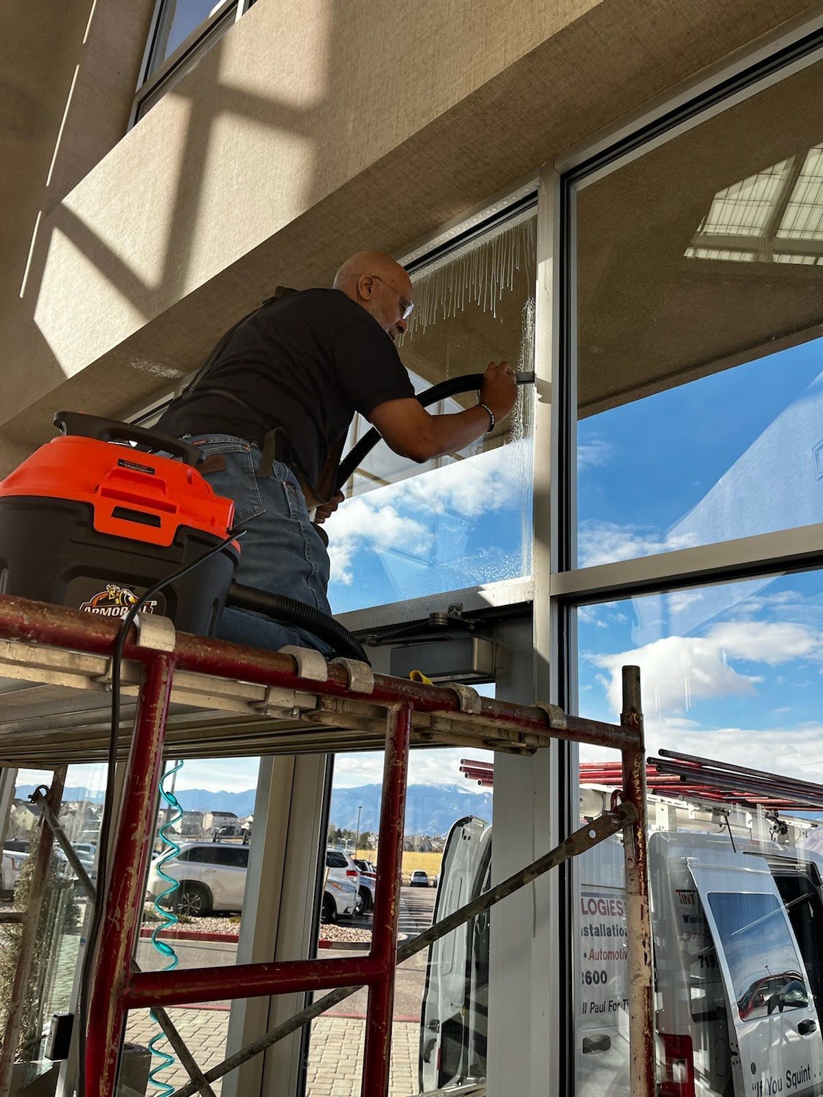 Paul Hasty is installing commercial window tint on a window 