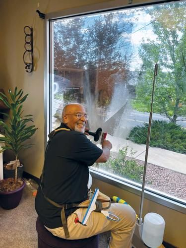 Paul Hasty installing window tint at the Colorado Springs Black Chamber of Commerce.