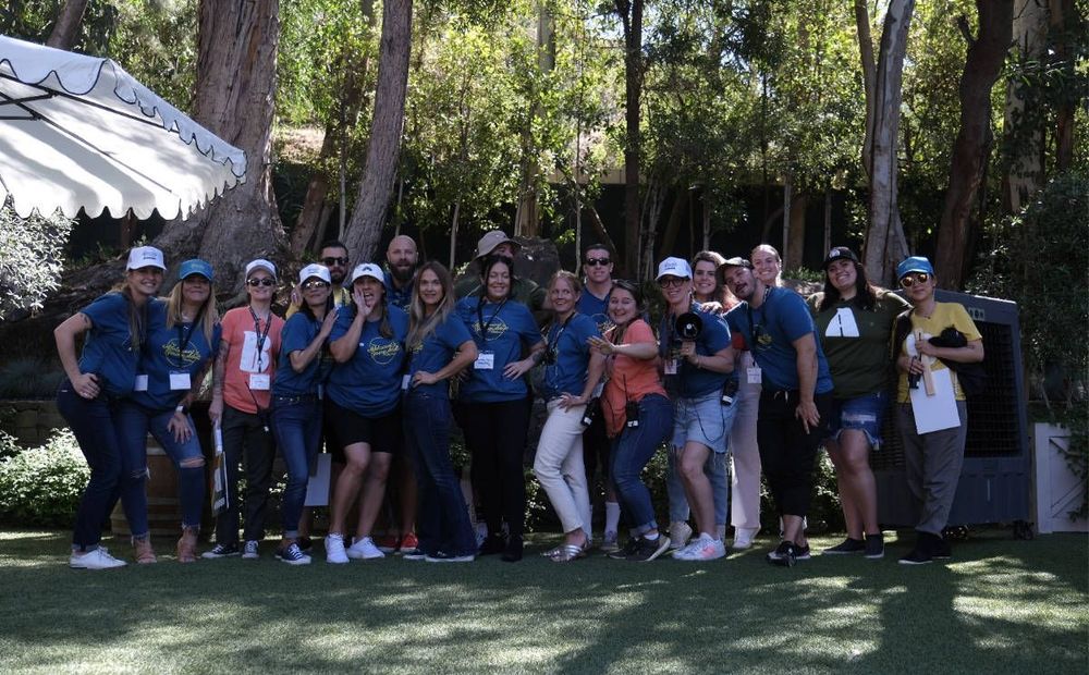 A group of people are posing for a picture in a park.