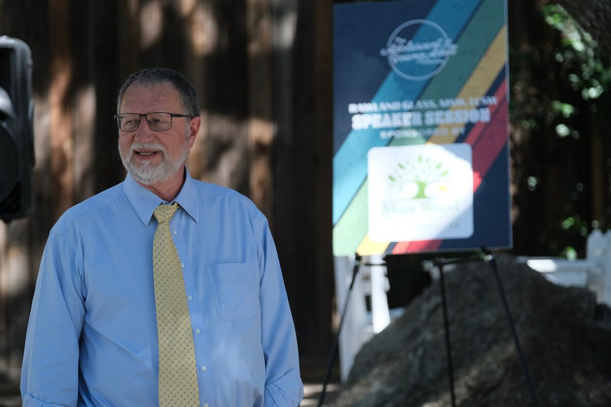A man stands in front of a sign that says speakers league
