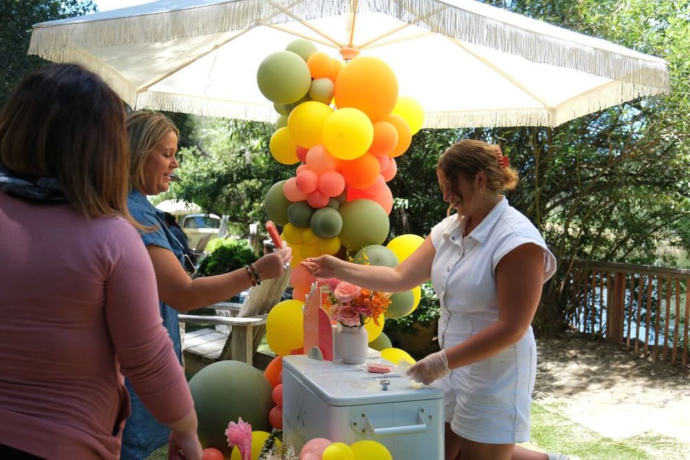 A woman is standing in front of a bunch of balloons