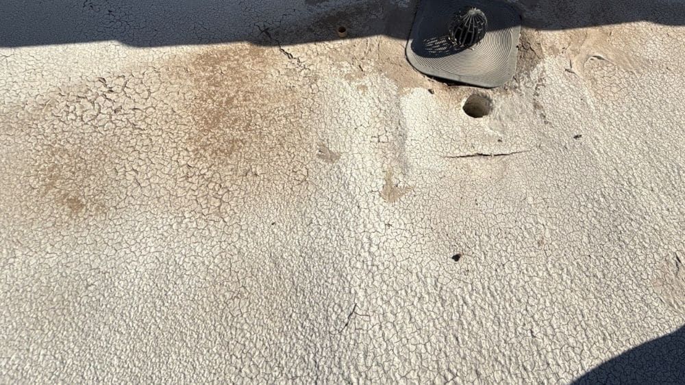 Close-up of a sandy concrete surface with a small hole near the top edge.