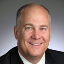 A man in a suit and tie is smiling for the camera