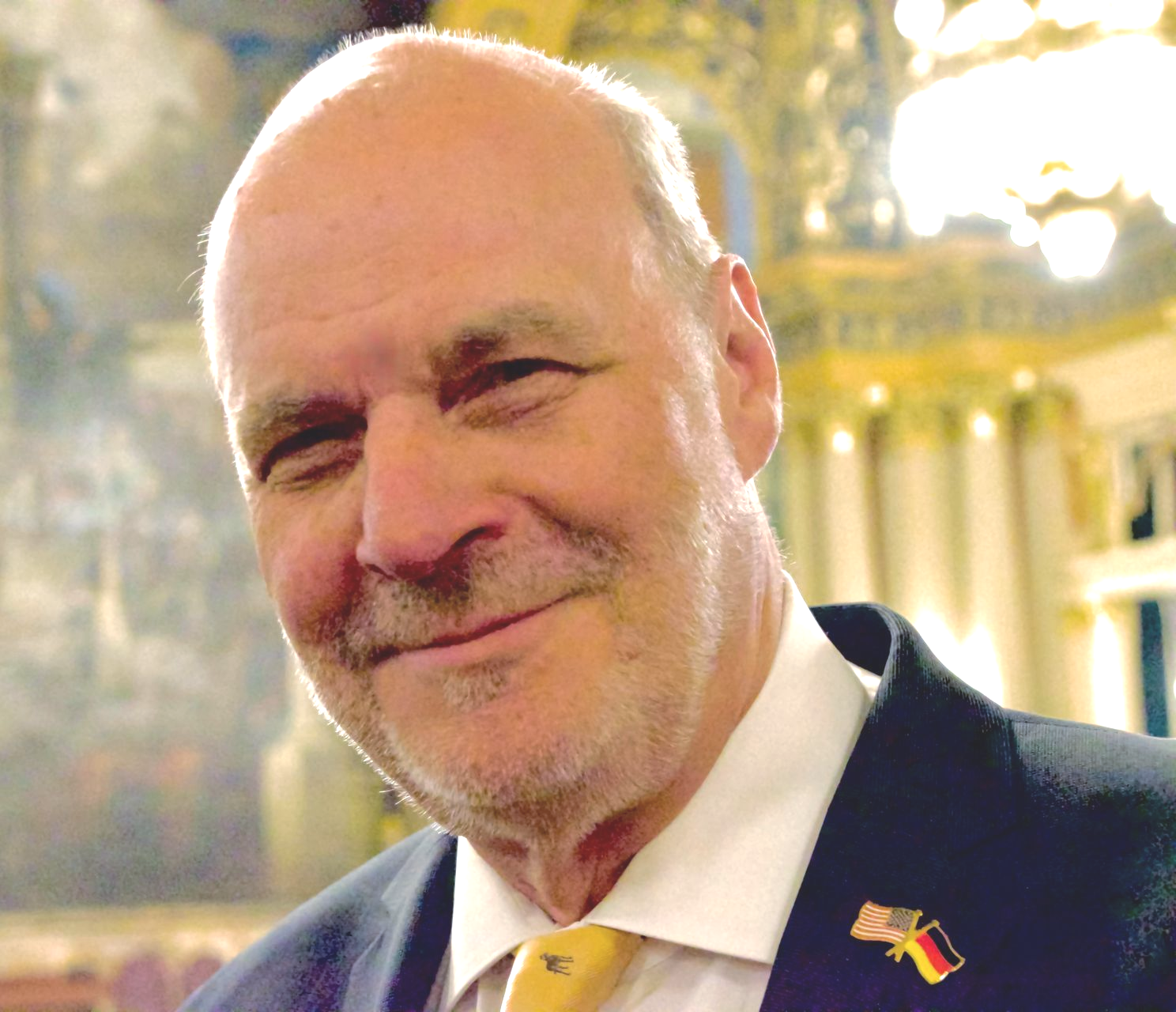 A bald man with a beard wearing a suit and tie