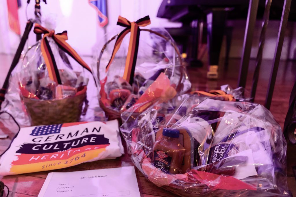 Gift baskets and a packet of noodles on a table, wrapped in clear cellophane with ribbons.