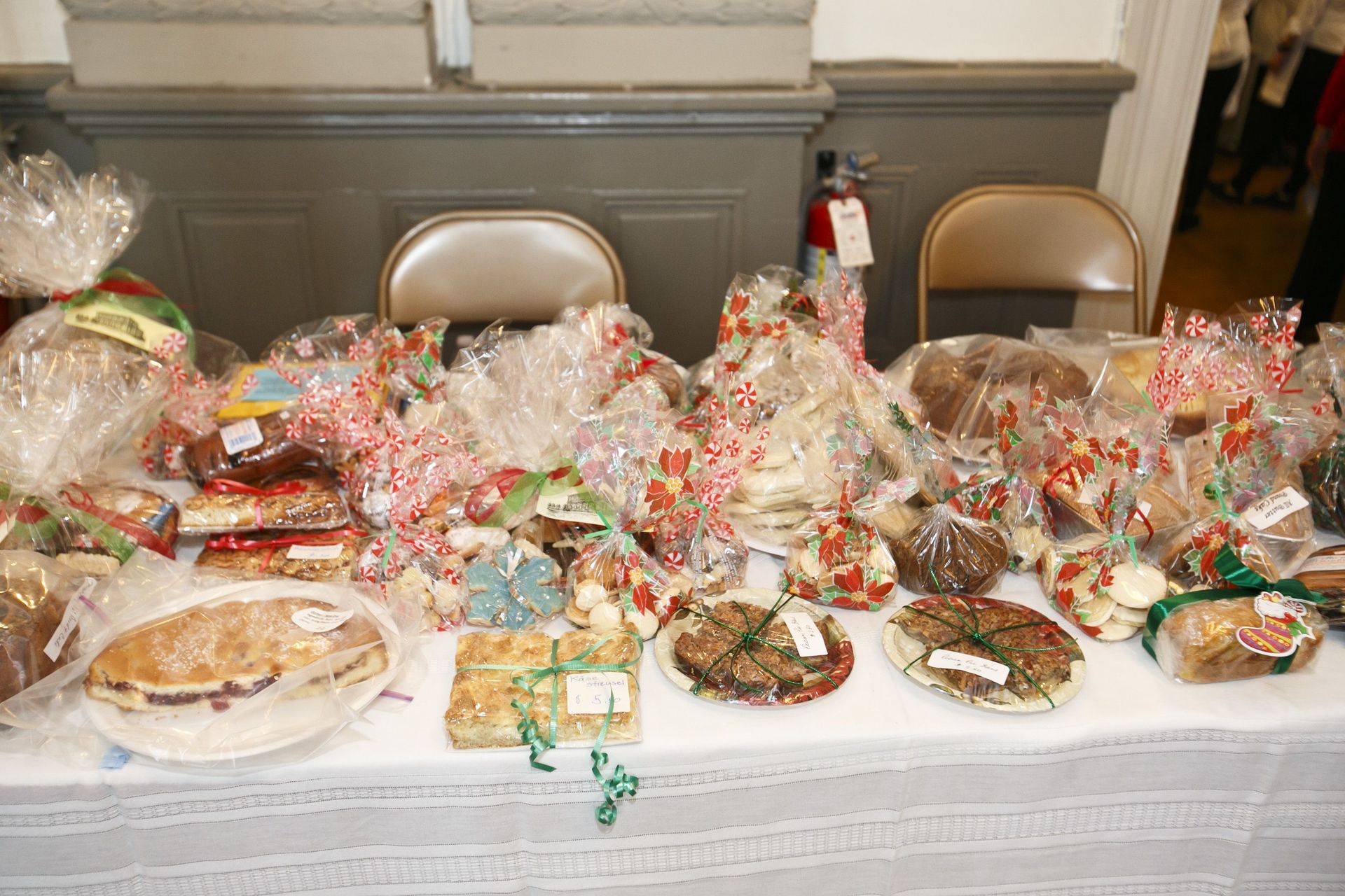 Table covered with wrapped gift baskets and plates at a holiday gathering