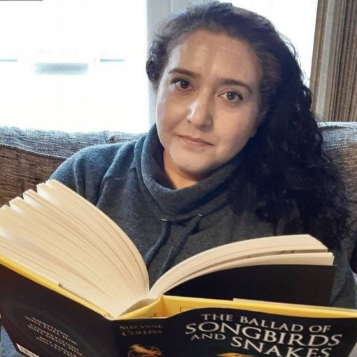 Woman with dark curly hair reads 