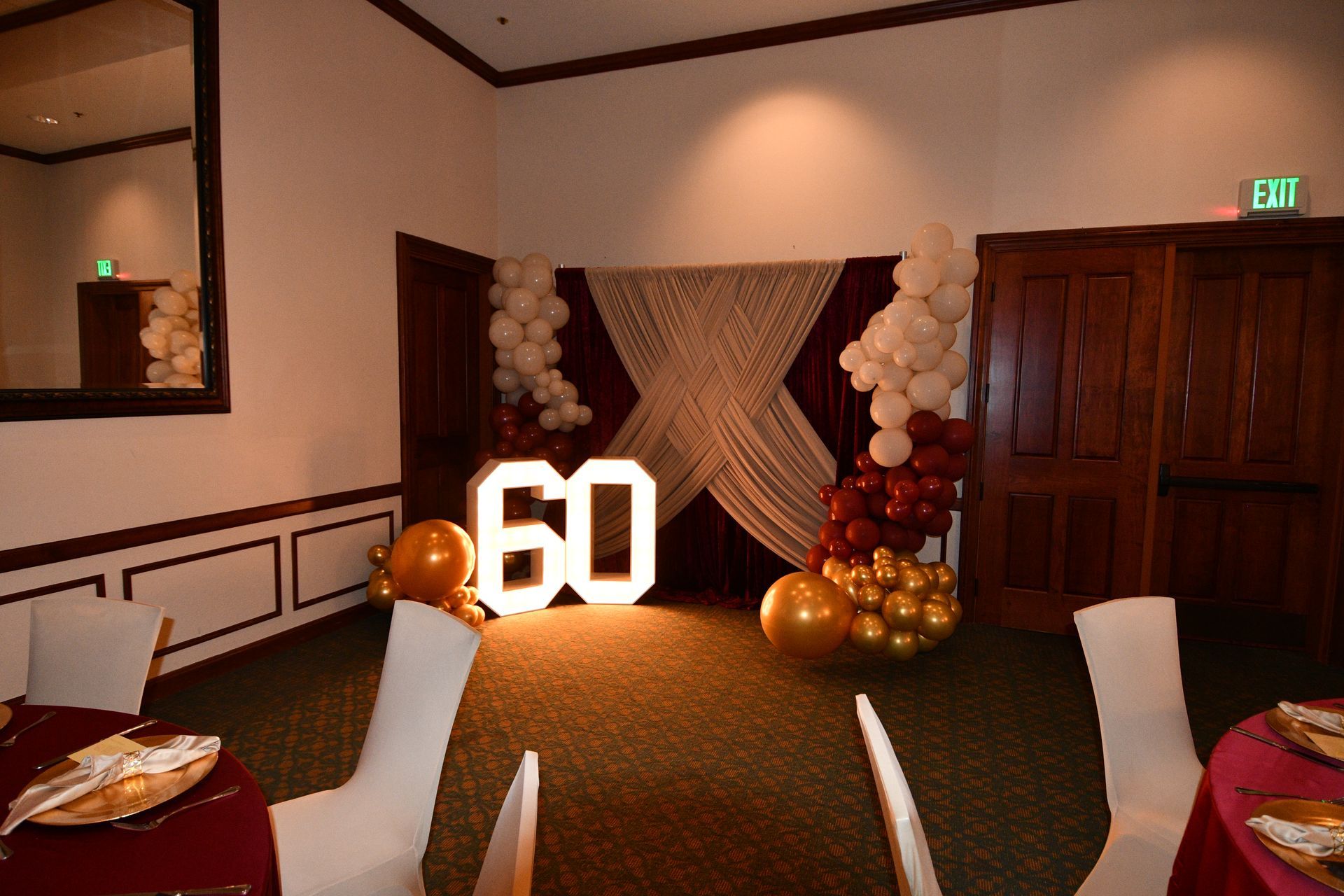 A room decorated for a 60th birthday with balloons and lighted 