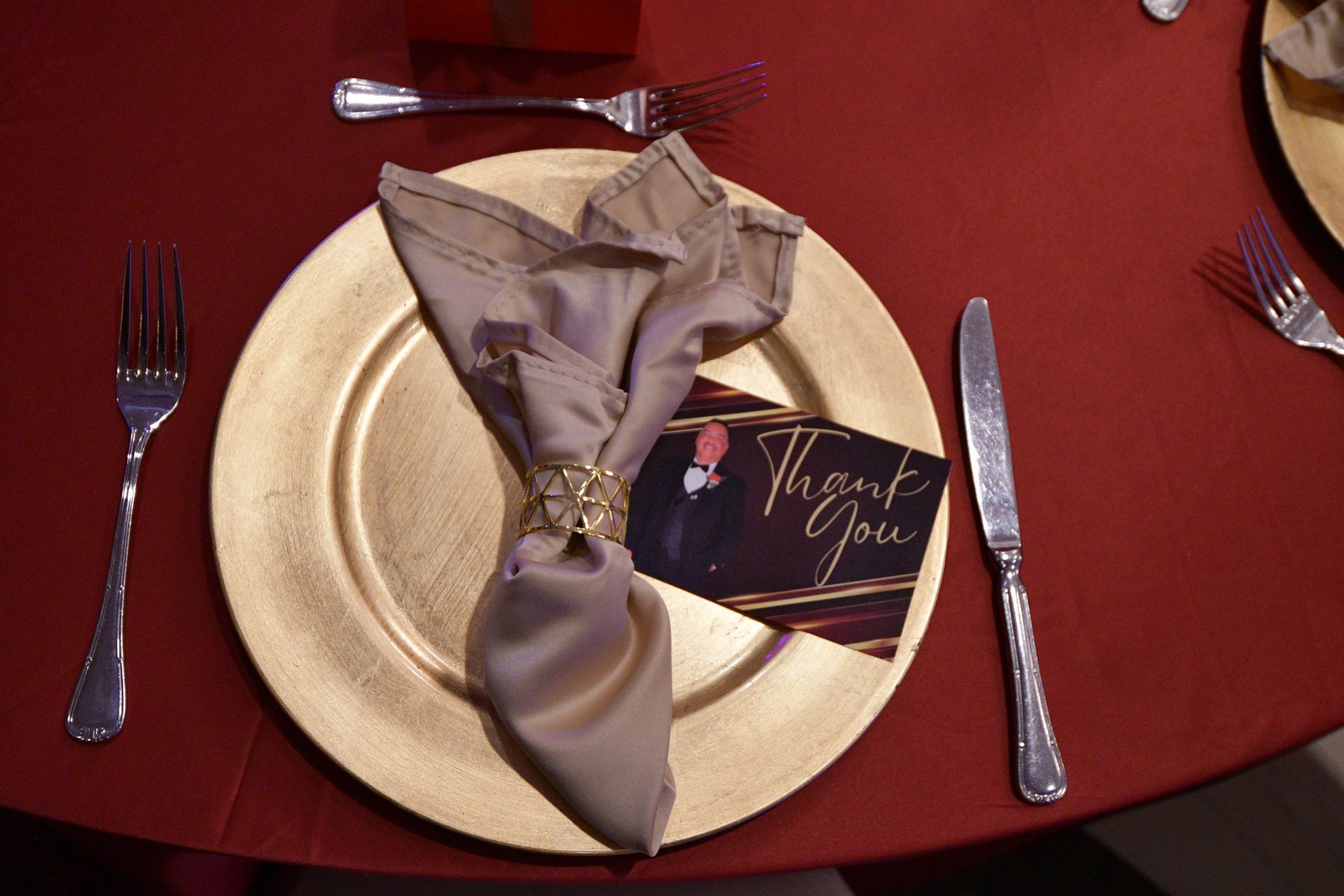 Gold-rimmed plate with folded beige napkin, 
