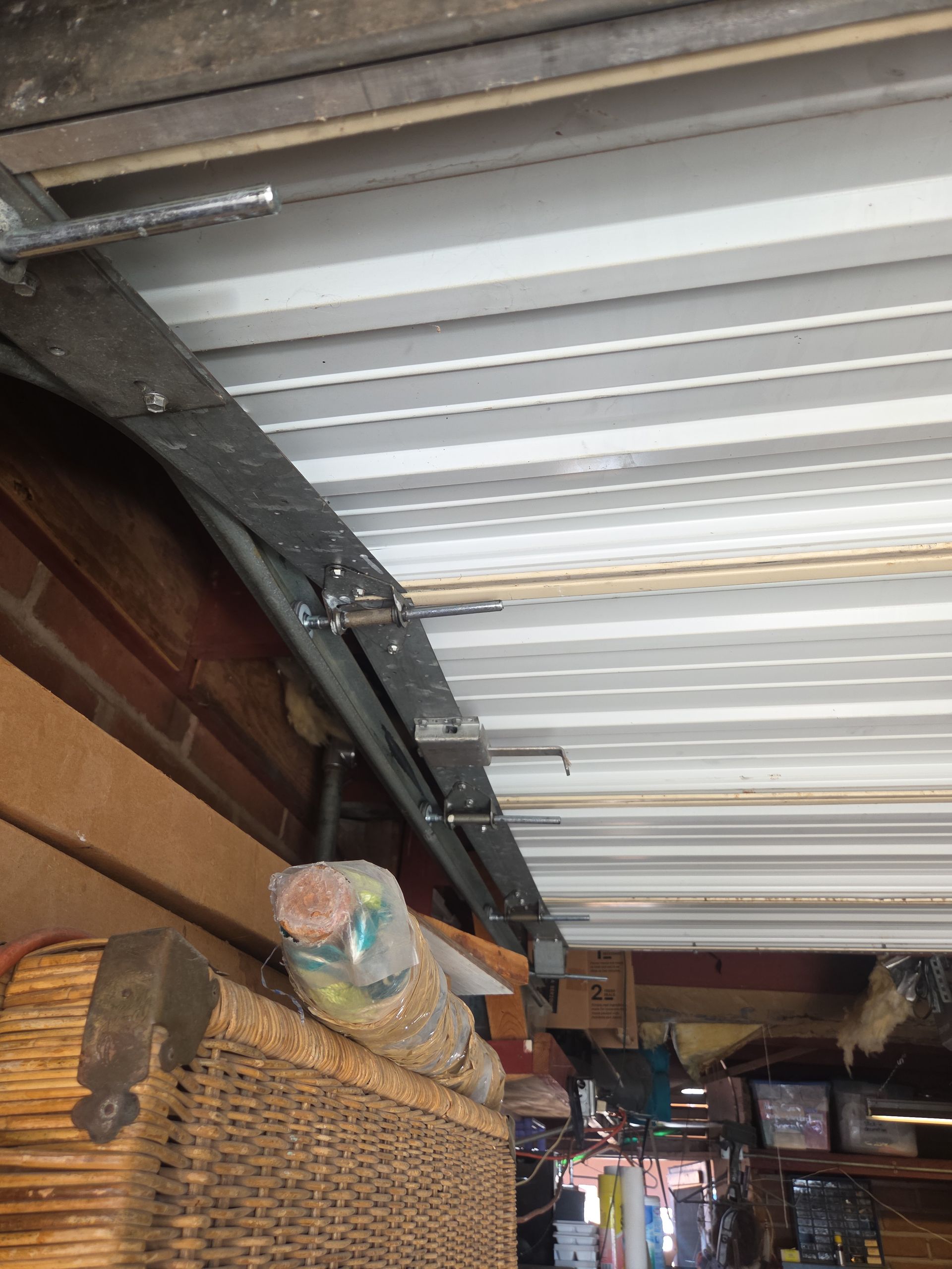Inside a storage area with a corrugated metal roof and stacked boxes, viewed upward toward the ceiling