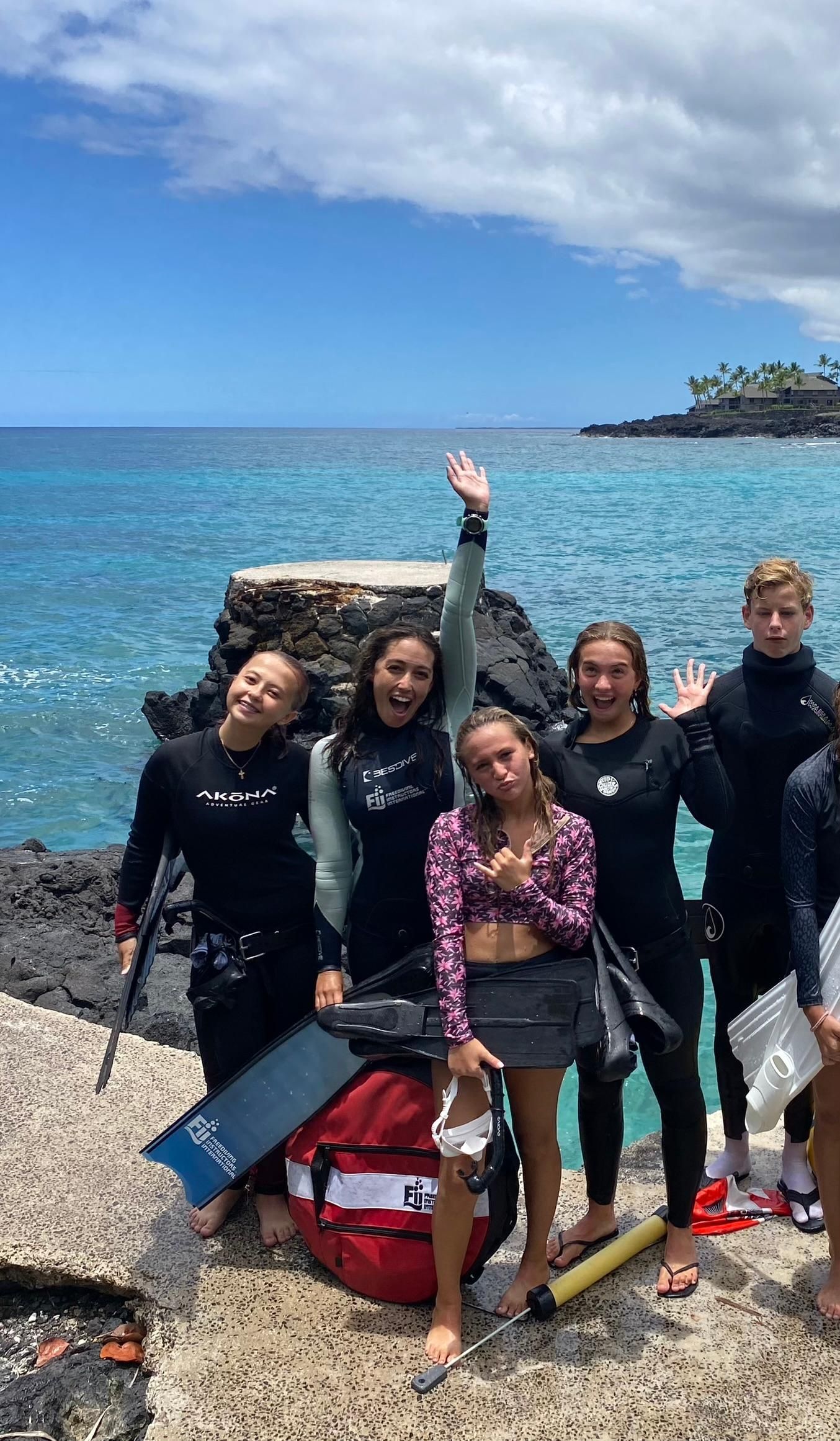 A group of people are posing for a picture on a beach.