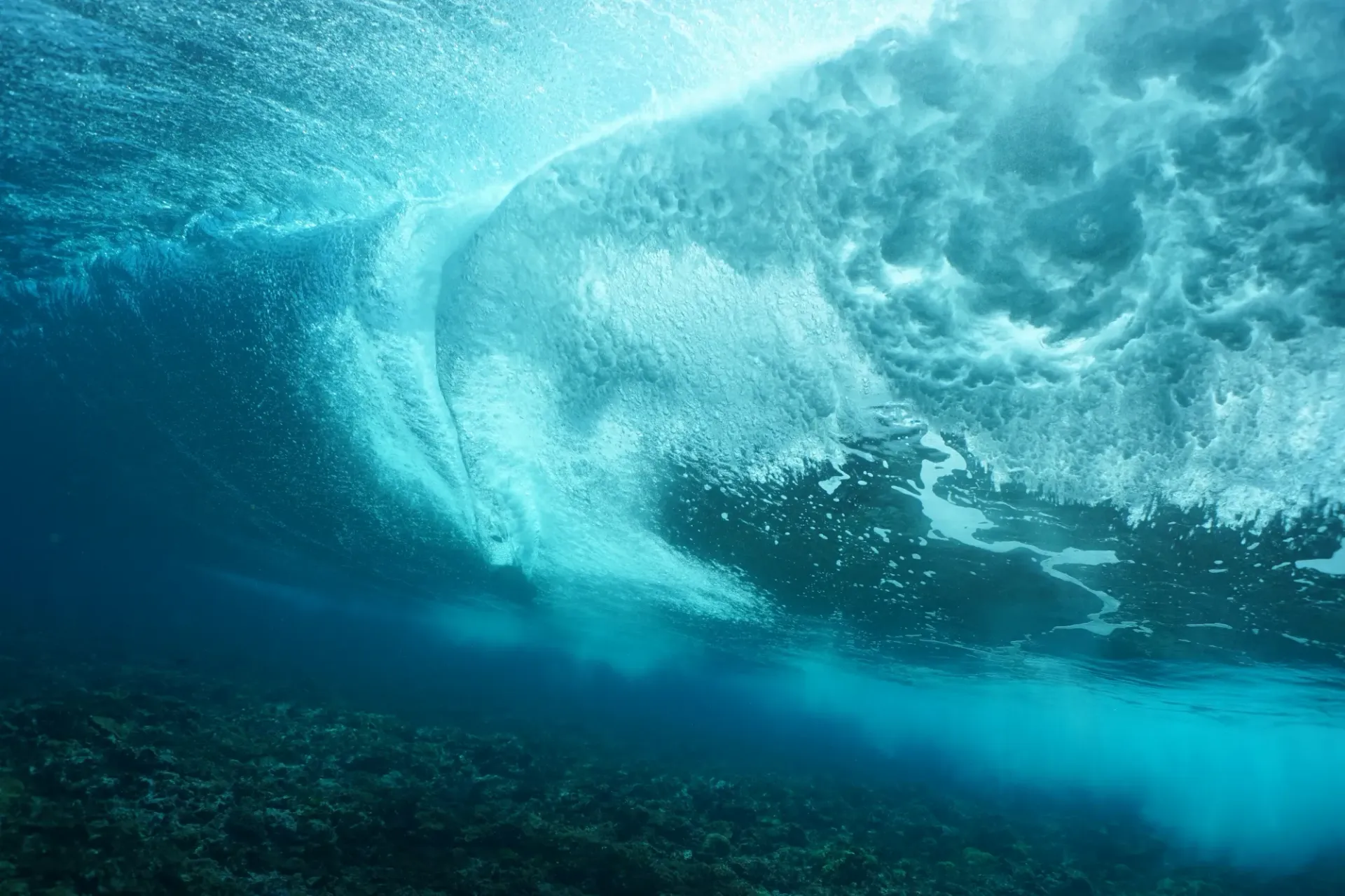 A wave is crashing on a coral reef in the ocean.