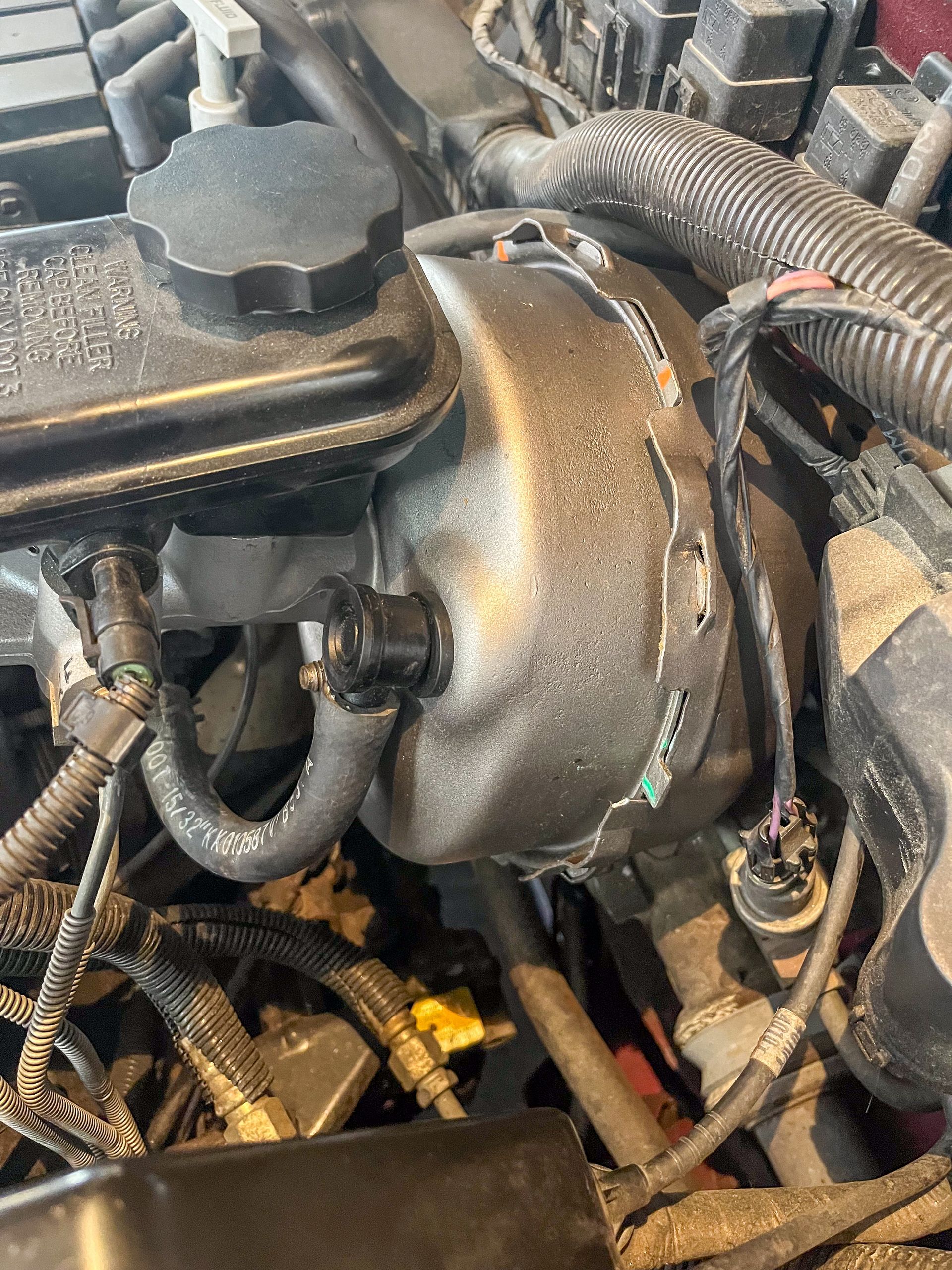 Car engine bay with brake booster, brake fluid reservoir, and hoses. | Jim Brangham Auto Repair