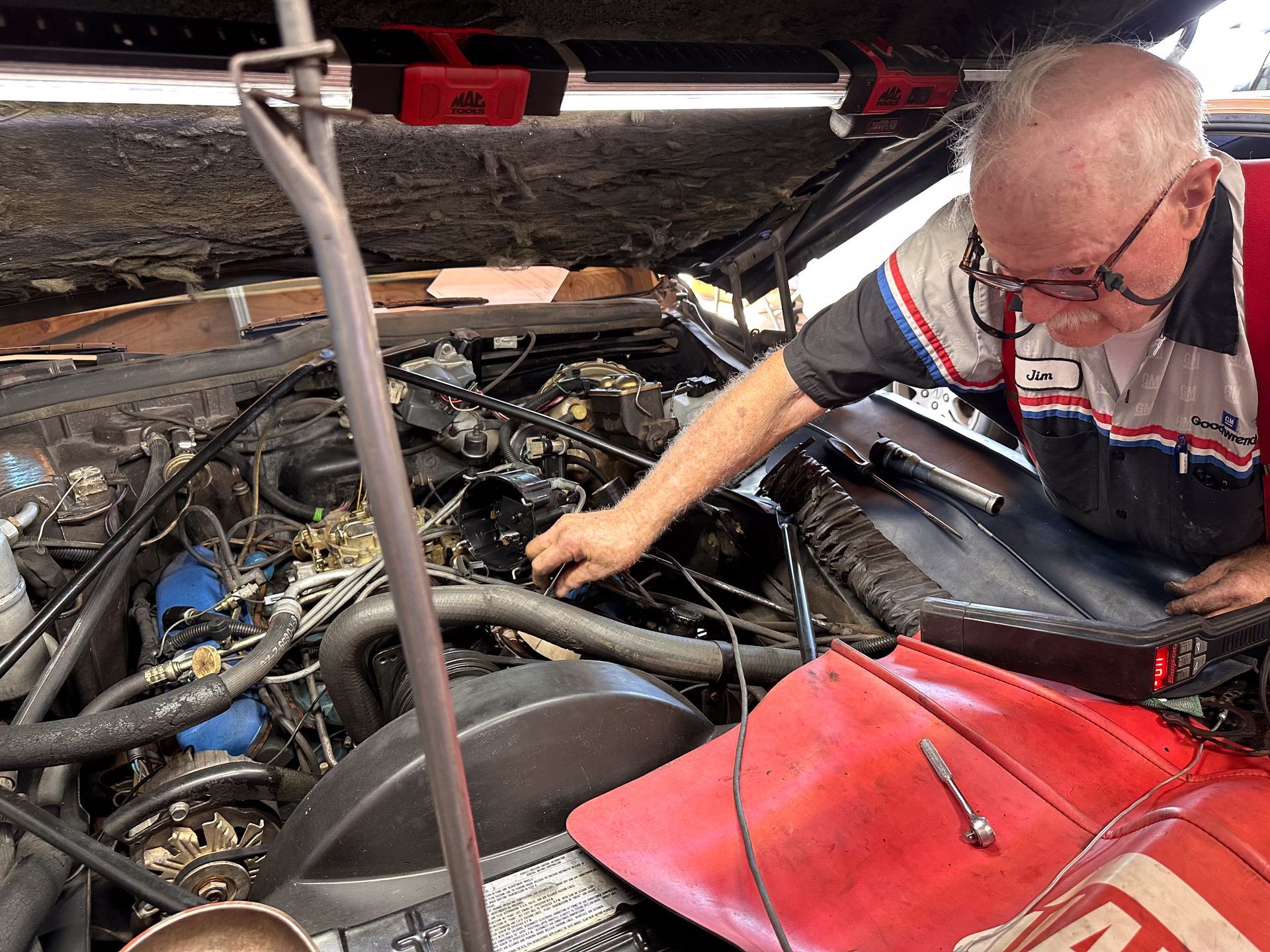 Mechanic working on a car engine, with tools and diagnostics. Wearing a work uniform, focused, inside a garage. | Jim Brangham Auto Repair