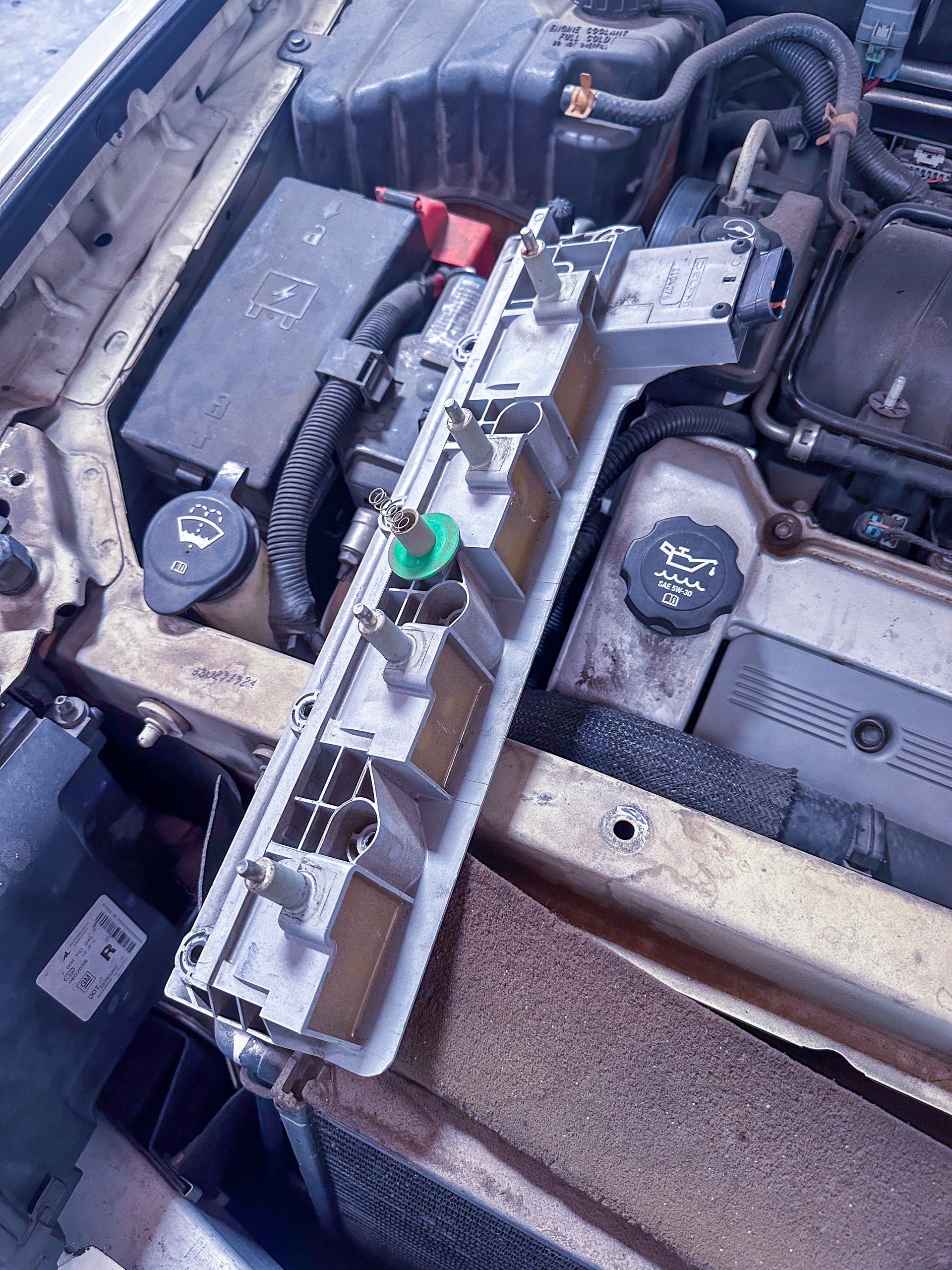 Engine bay with a long, detached component, likely part of the vehicle's electrical system. | Jim Brangham Auto Repair