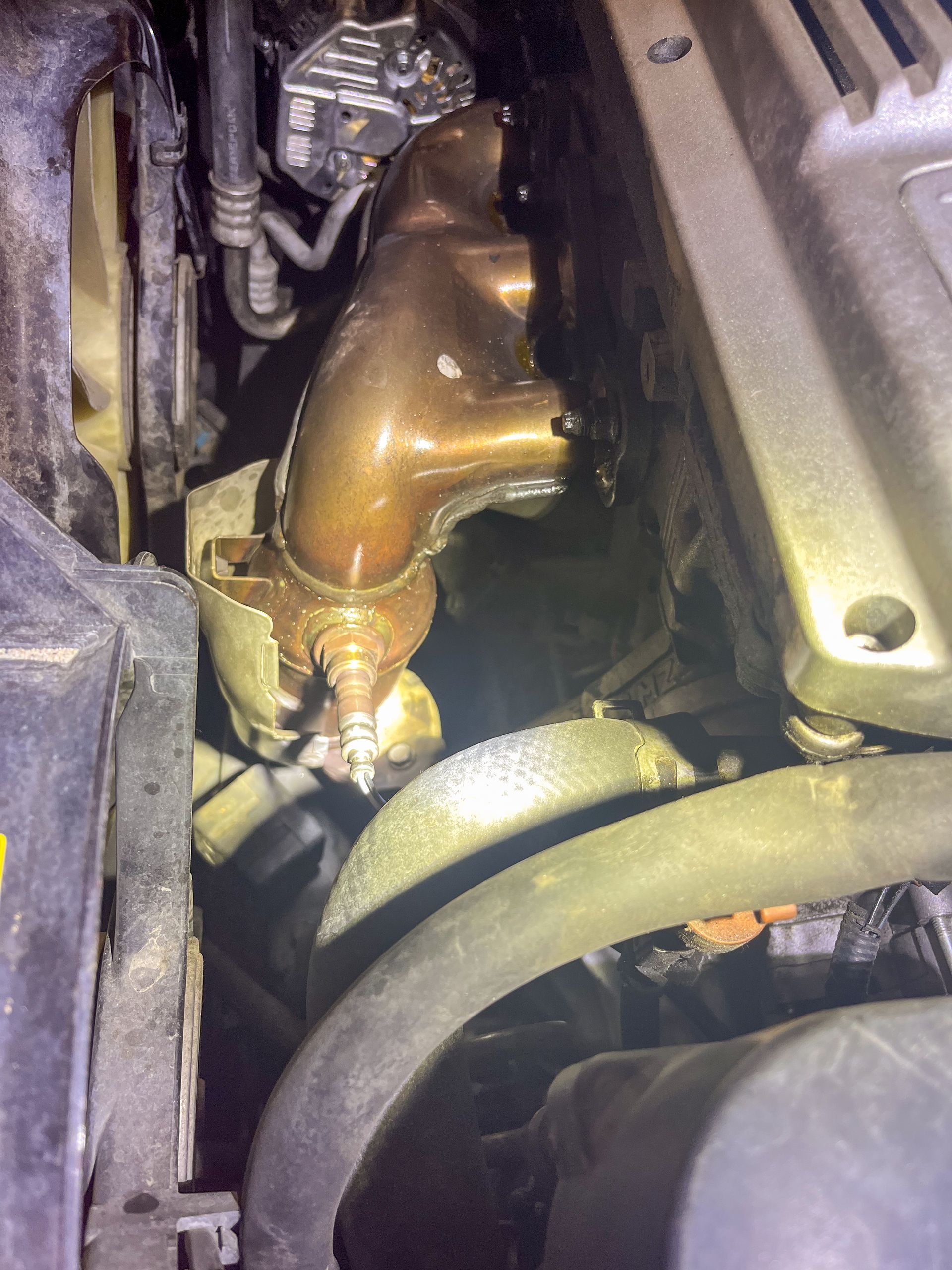 Close-up of a rusty vehicle exhaust manifold and engine components. | Jim Brangham Auto Repair