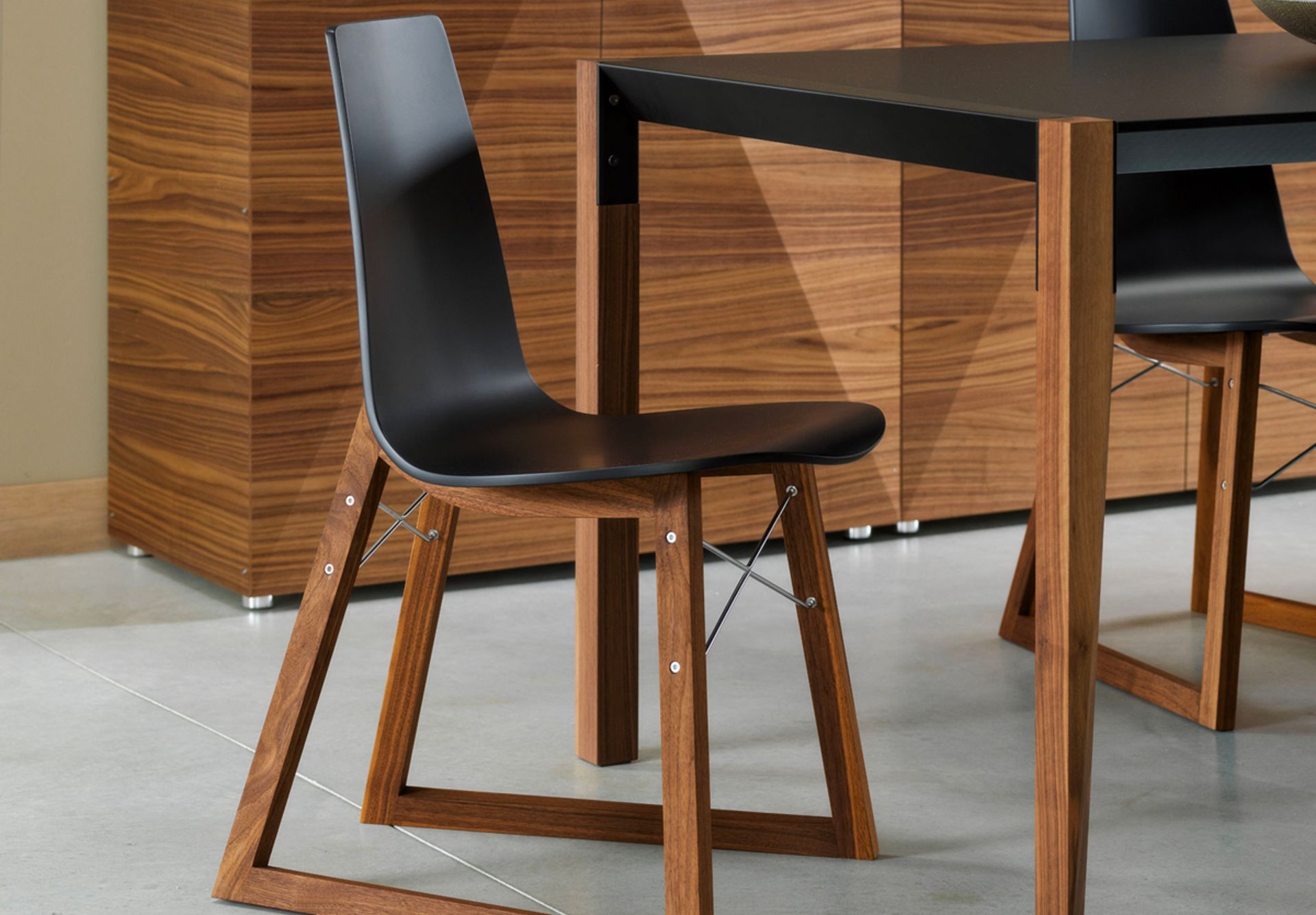 The name and the X that distinguish the front of this chair are a clear reference to Charles and Ray Eames. The comfortable curved plywood seat is supported by a sled made of wood or chrome rod, giving the Ray chair a strong aesthetic presence.
