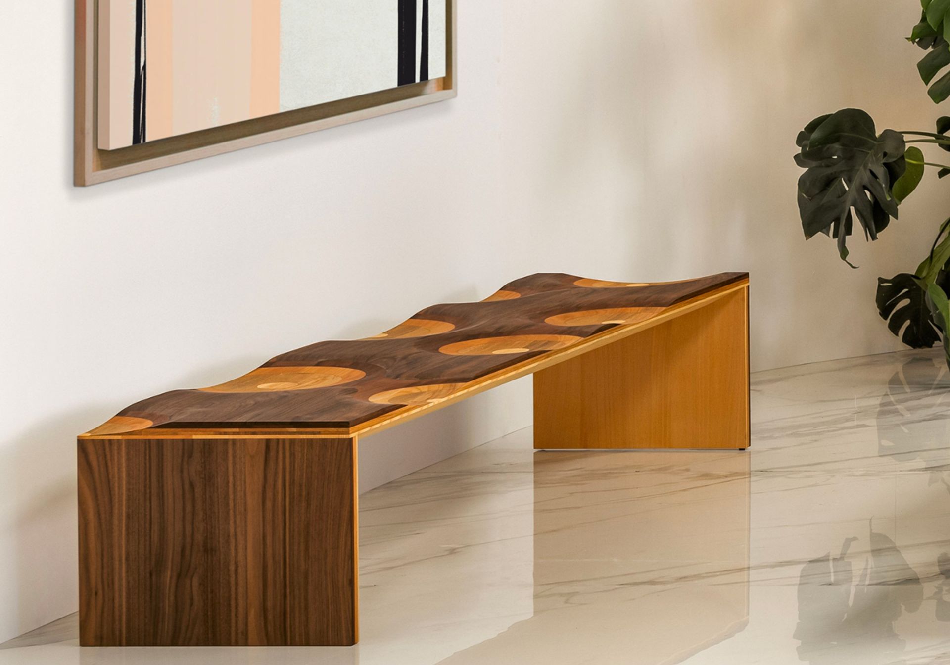 Ripples, winner of the 2004 Compasso d’Oro, is made of a laminated composite of five different solid woods. Slide your hand along the surface to enjoy the seamless transitions between walnut, mahogany, cherry, oak, and ash. This enveloping seat, carved with mastery, is hand-finished to produce an elegant polychromatic effect arising from the ductility of the wood. A true icon of international design, Ripples is a bench suitable for home users, commercial environments, and public spaces.