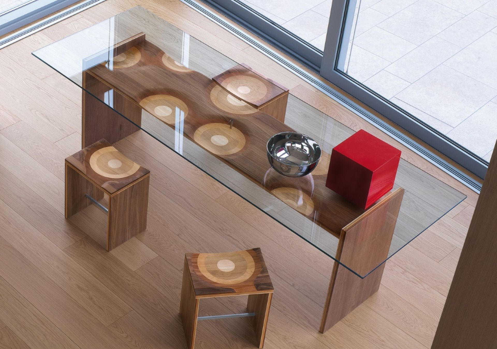 The Ripples bench by Toyo Ito, winner of the 2004 Golden Compass, has blossomed into a collection of different furniture complements. Amongst them, we may highlight the Ripples stool, fabricated with a laminated composite of five different solid woods. The seat shape, carved with industrial technology yet entirely hand-finished, feels soft and rich due to both the ductility of wood and Horm’s passion for craftsmanship. Slide your hand along the surface to feel the seamless transition between walnut, mahogany, cherry, oak and ash.