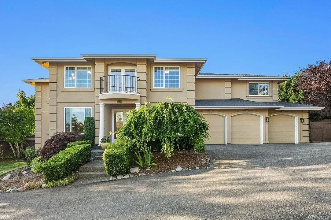 A modern house with a large garage and a lush green lawn.