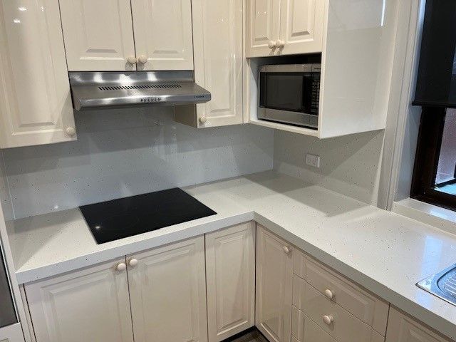 Cream kitchen with white countertops, stainless steel appliances, and built-in microwave — Wards Kitchens in Berkeley Vale, NSW