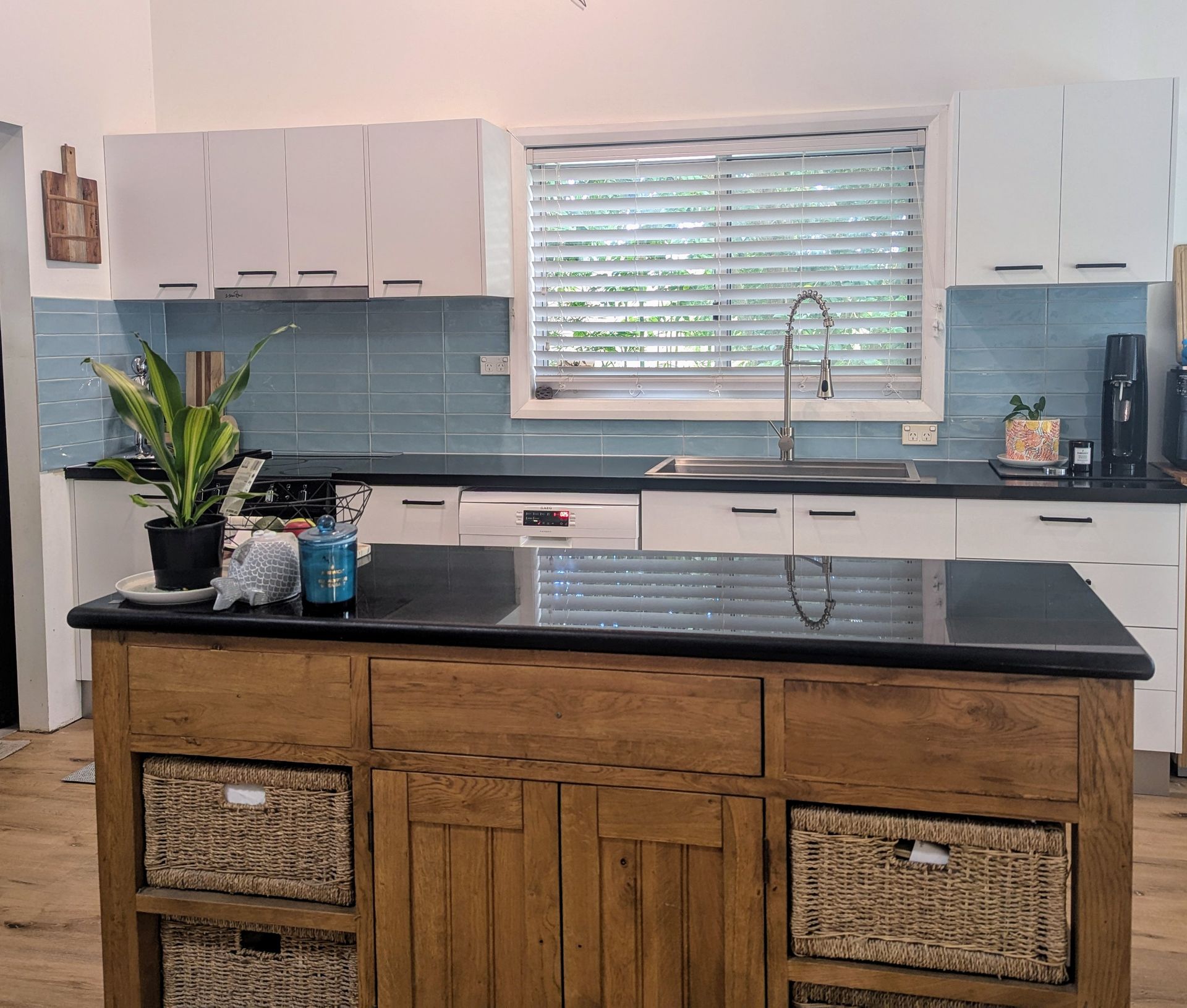 Kitchen with a wooden island, blue tile backsplash, and white cabinets — Wards Kitchens in Berkeley Vale, NSW