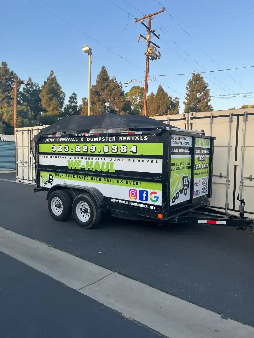 a green and white trailer is parked on the side of the road .