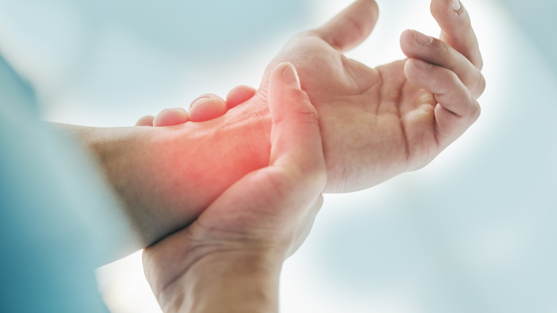 a person is holding their wrist in pain .