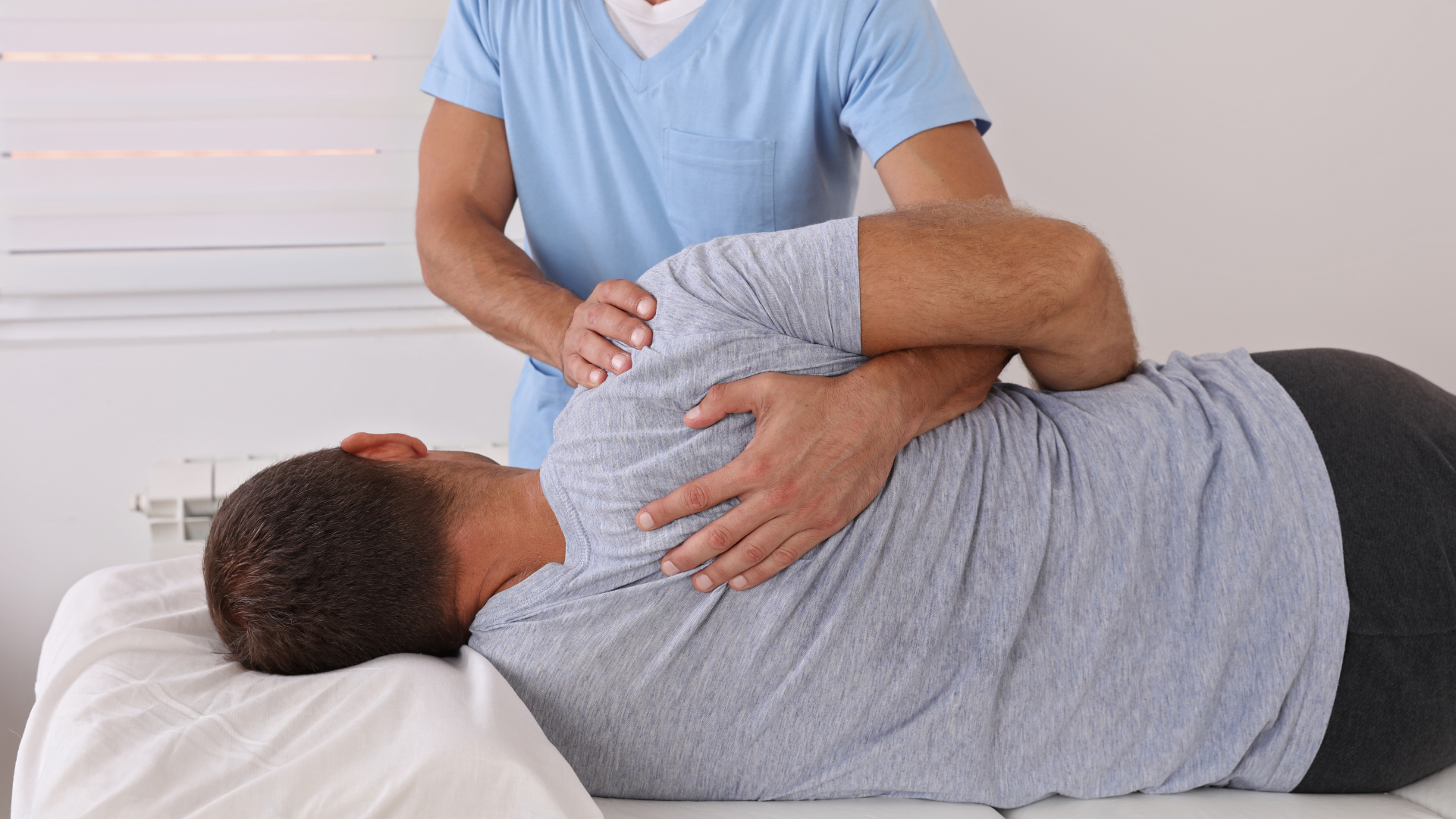 a man is laying on a bed getting a massage from a doctor .