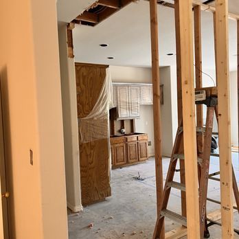 A ladder is sitting in the middle of a room in a house under construction.