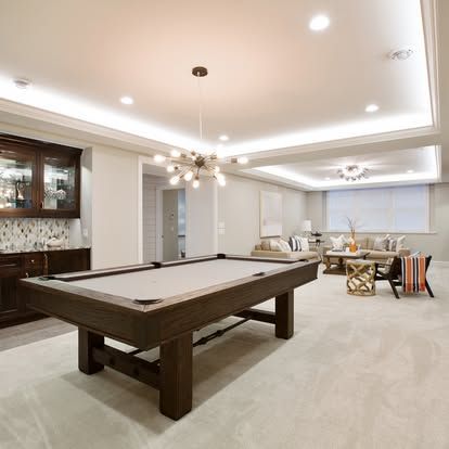 There is a pool table in the middle of the room.
