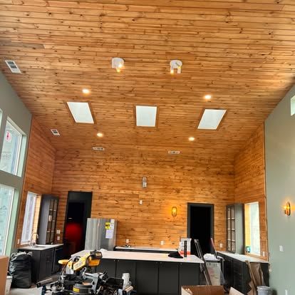 A kitchen with a wooden ceiling and a lot of windows.