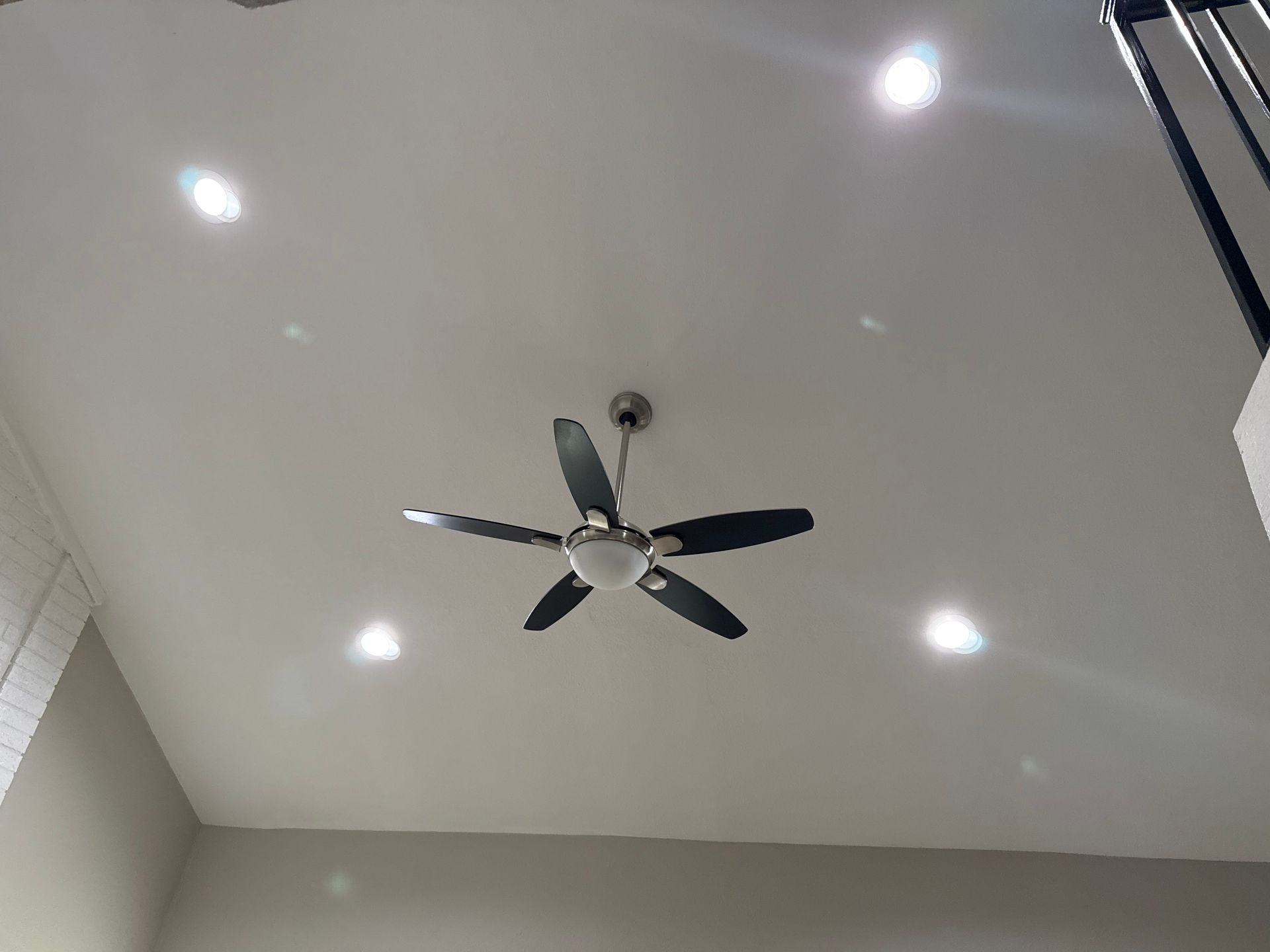 A ceiling fan is hanging from the ceiling of a room.