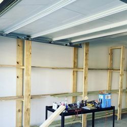 A garage with wooden shelves and a table in it.