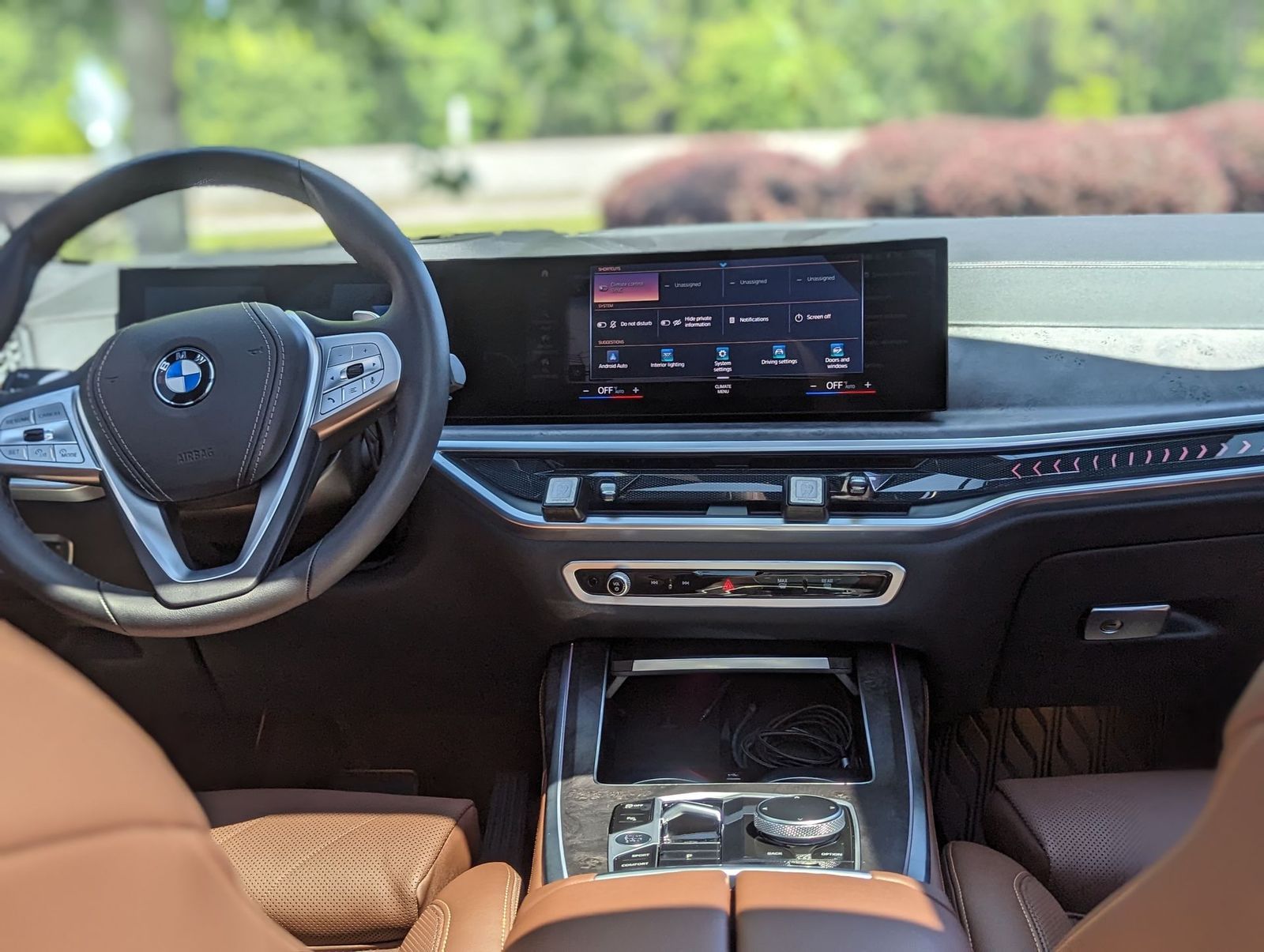 Brown BMW interior with dashboard display, steering wheel, and console.