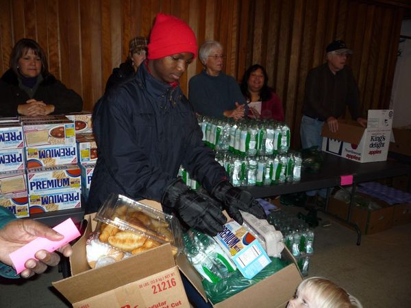 Volunteer packing a box of food at a community pantry