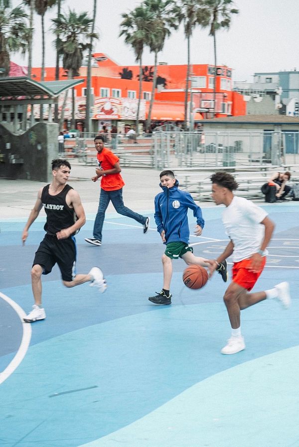 Young people playing basketball on a colorful community court