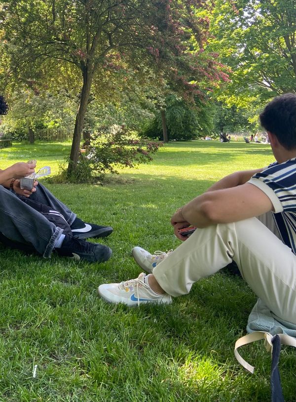 Two people relaxing on the lawn of a sunny park