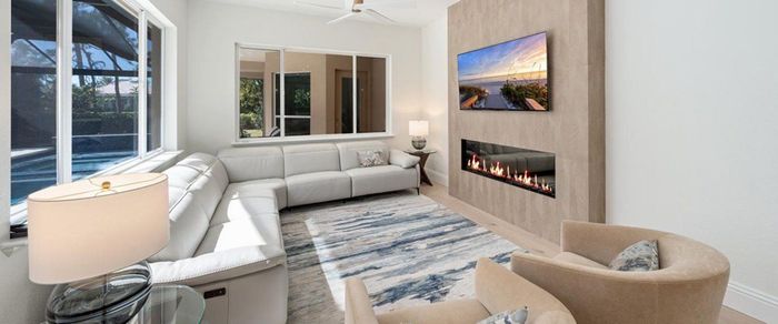 A living room with a couch, chair, television and fireplace. A living room with a couch, chair, television and fireplace.