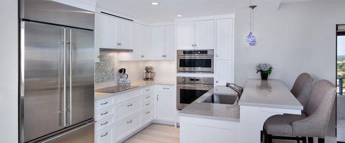 A kitchen with white cabinets and stainless steel appliances. A kitchen with white cabinets and stainless steel appliances.