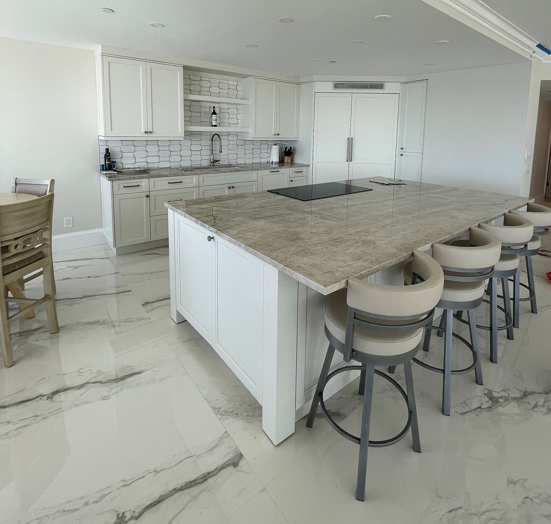A kitchen with granite counter tops and white cabinets.