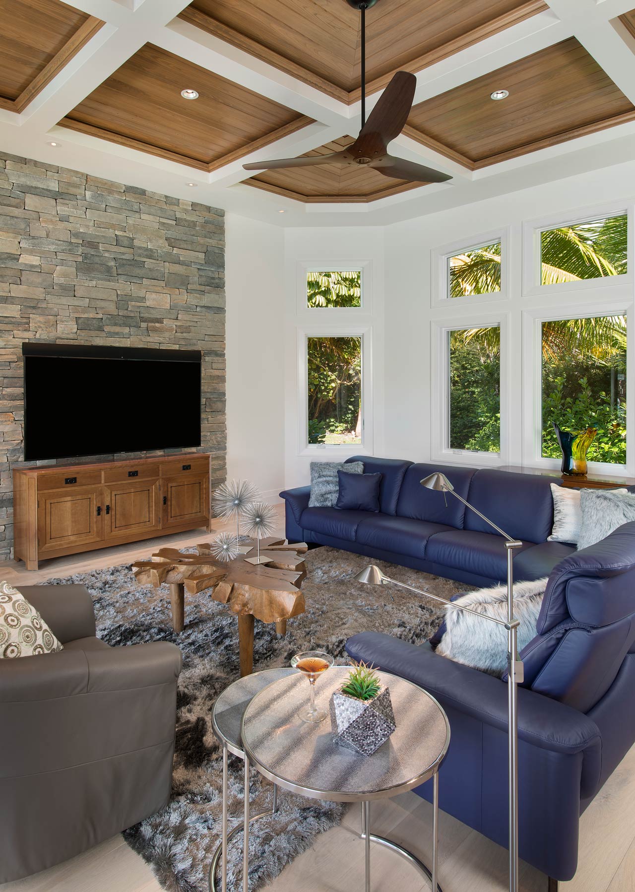 A living room with a blue couch and a flat screen tv.